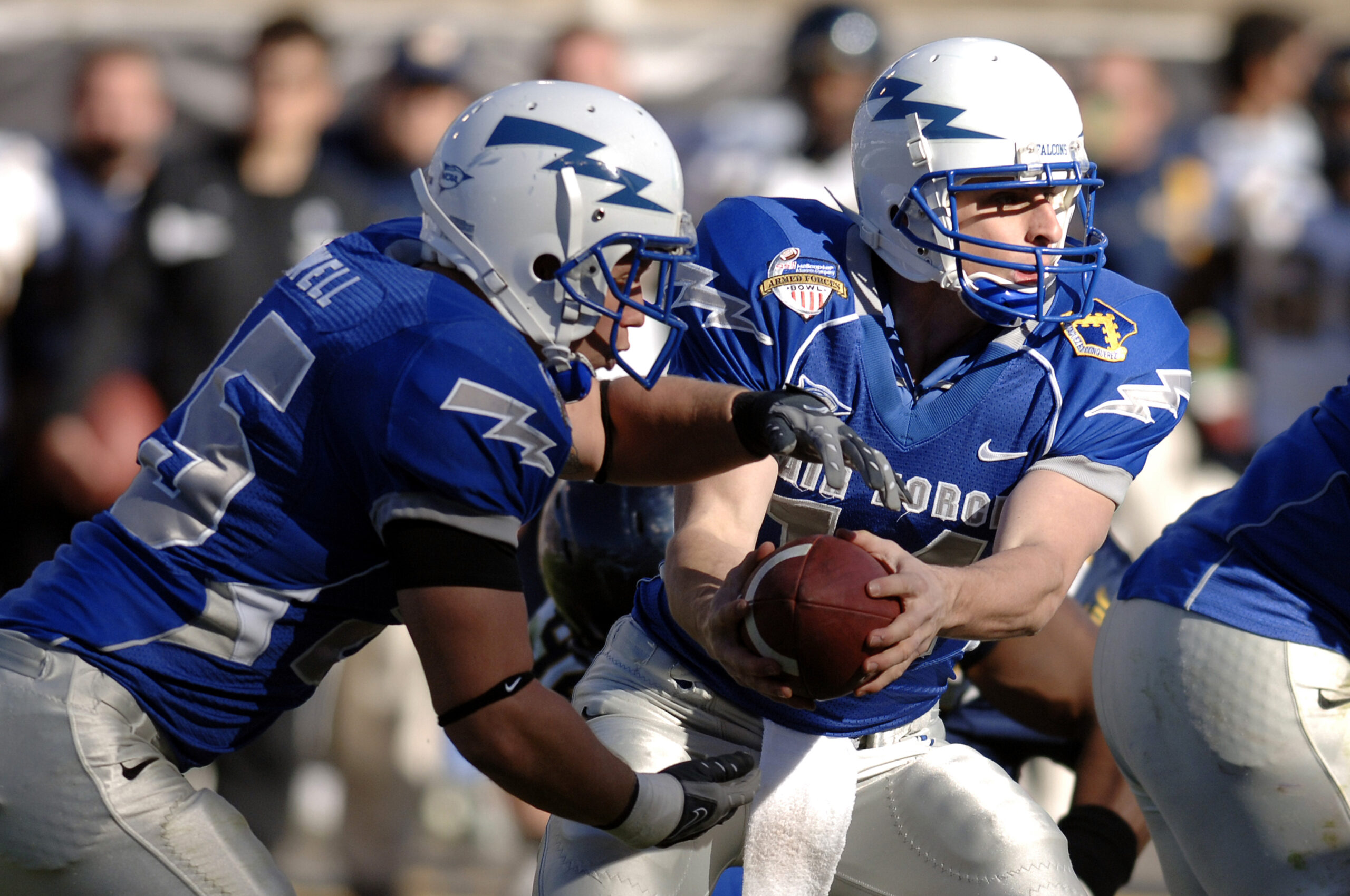 Football players executing a handoff